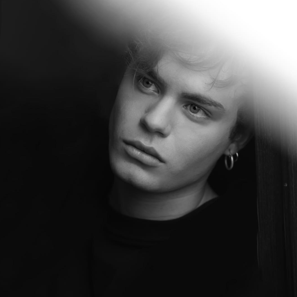 Luca Gremita a mezzo busto, in bianco e nero, con un fascio di luce che riempie la parte in alto a destra dell'immagine.